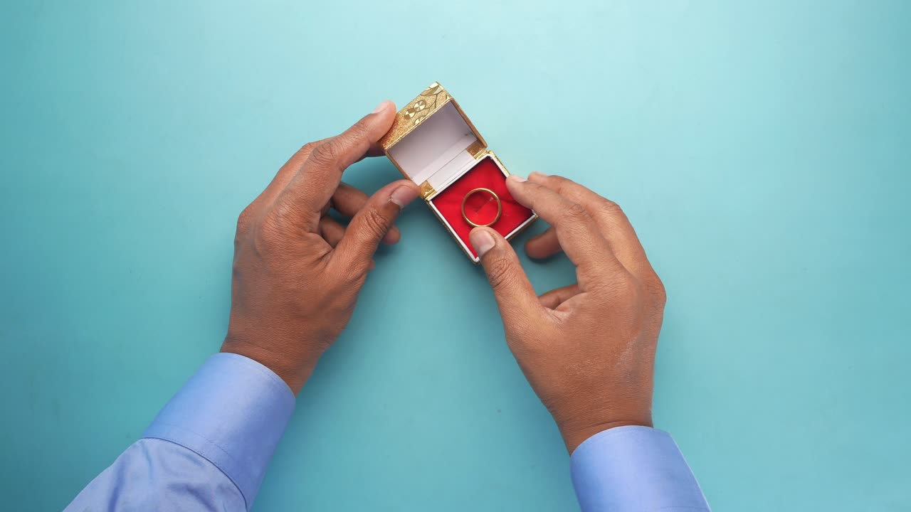 Young man hold a wedding ring in a box