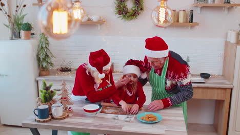 Grandparents-with-grandchild-preparing,-cooking-homemade-cookie-roll-out-dough,-Christmas-kitchen