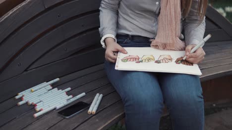 woman drawing hands on a bench