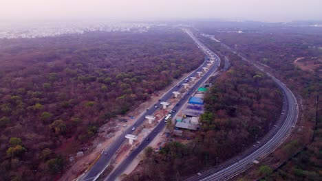 under construction flyover with railway track and trees at suchitra, hyderabad, telangana, india. day time, semi orbit, drone shot, 4k.