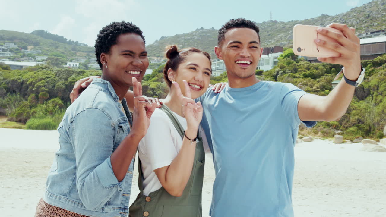 Segno della pace, selfie e sorriso con amici in spiaggia