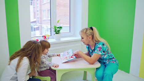 Doctor examining little patient. Beautiful young mother and her little daughter at the pediatrician