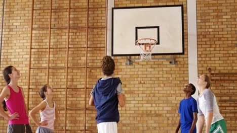 grupo de niños de secundaria jugando al baloncesto