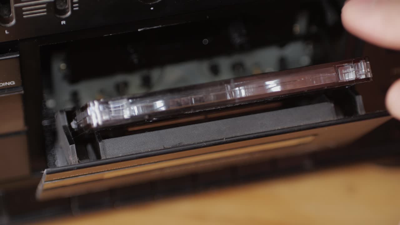 Retro radio tape recorder, audio cassette close-up. Listening to music, old radio boom box player, macro of vintage music listening.