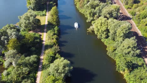 yacht-sailing-and-people-paddling-canoes-in-a-canal-Norwich,-England