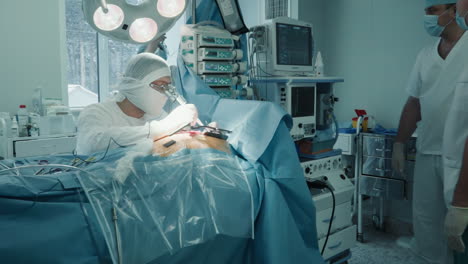 surgeon makes small cuts with laser scalpel in room. cardiologist uses accurate medical tool for coronary artery bypass surgery in clinic. heart disease