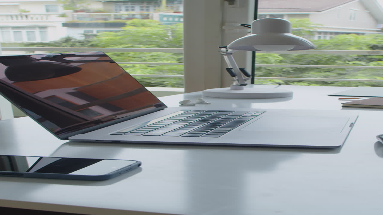 Scrivania con laptop, smartphone e lampada
