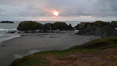 sunlight streaming through clouds above rock formation - elephant rock in bandon, coast of oregon