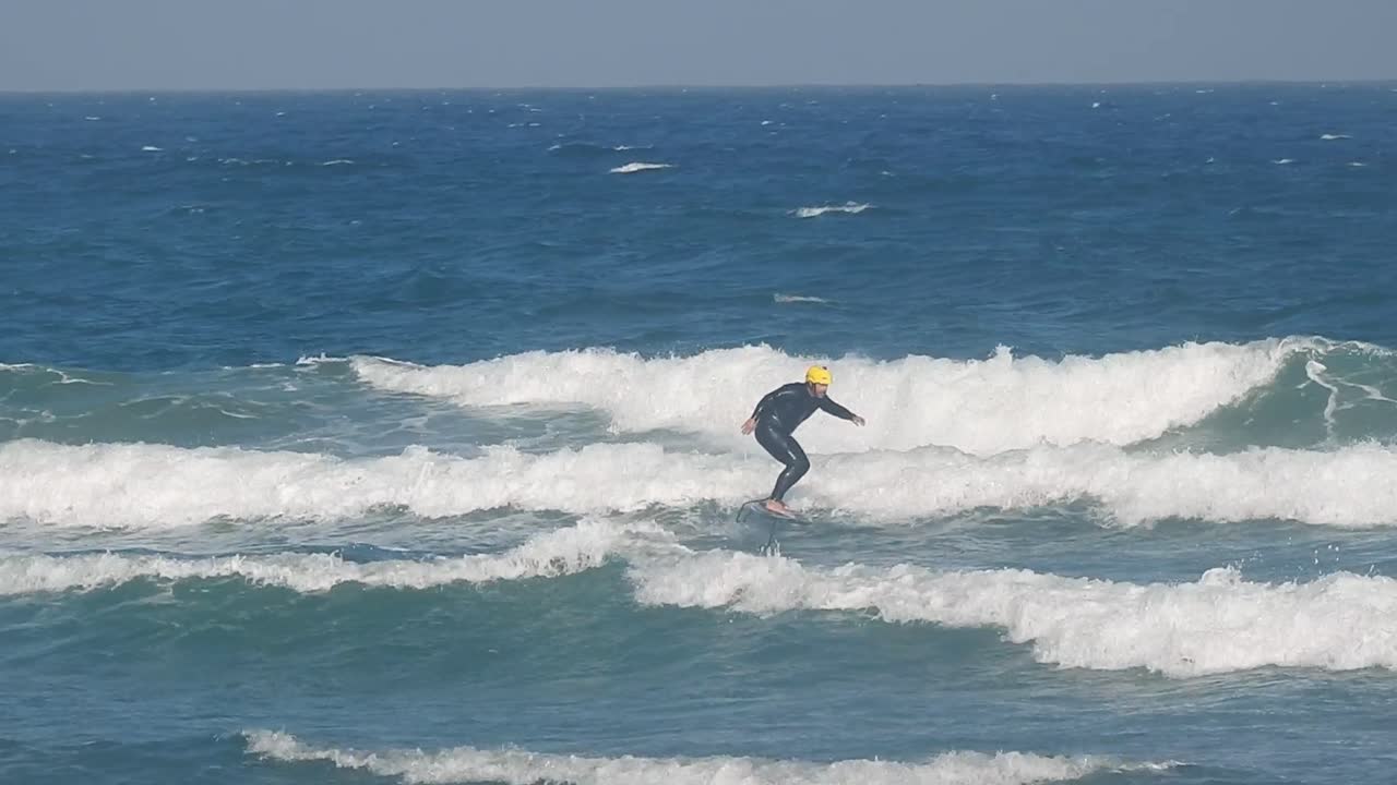 Fast foiler on ocean waves, elevated by a hydrofoil with strong wind, flying the surface at high speed, creating spray and dynamic energy. very fast