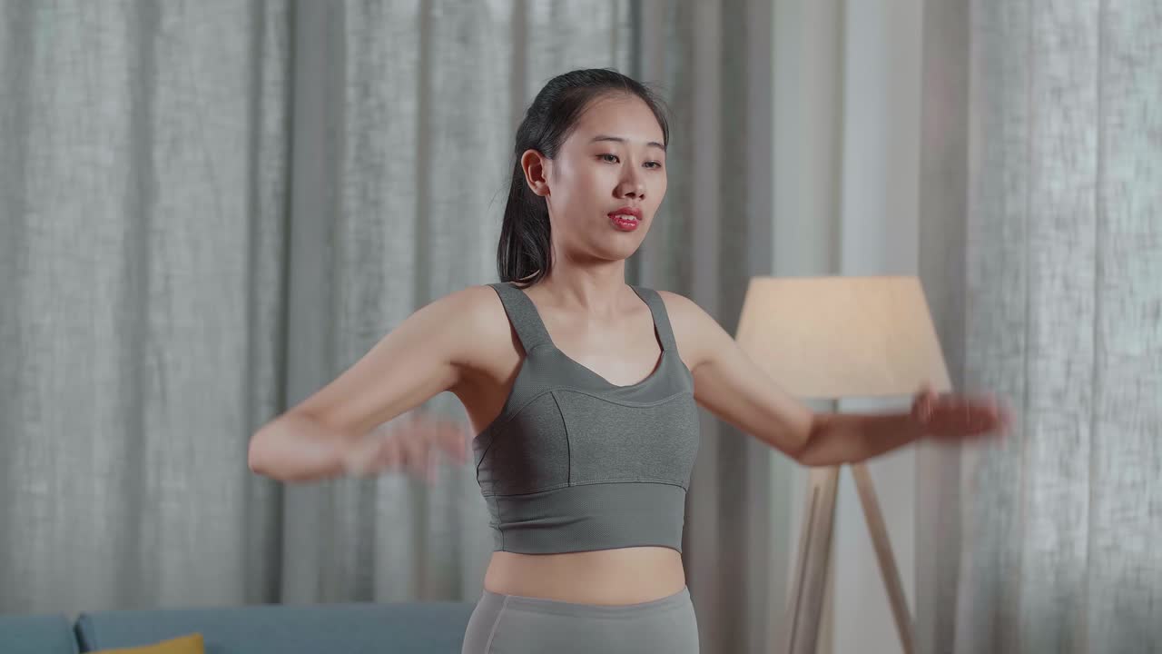 젊은 아시아 트레이너 스포츠 옷을 입은 여성이 집에서 운동을 가르치는 동안 심장 운동을 하고 고위 무을 고 있습니다.