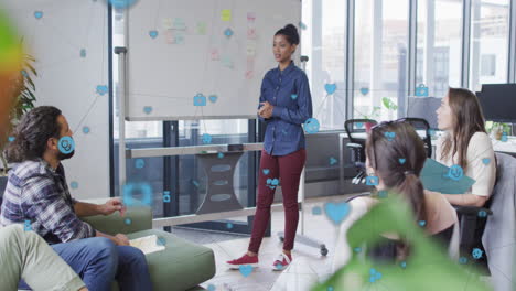 animation of network of digital icons against biracial woman giving a presentation at office