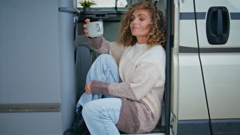 dreamy lady resting tea cup sitting trailer stairs closeup. attractive traveller