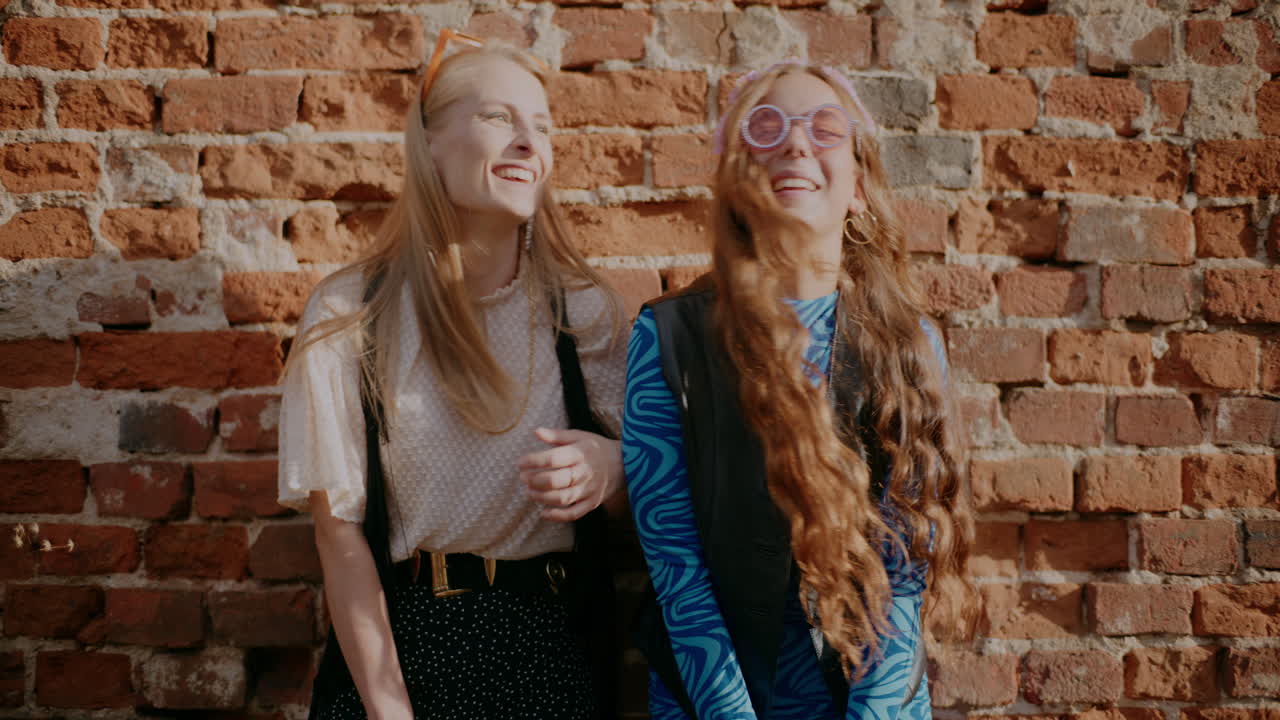 Twee vrouwen poseren voor een bakstenen muur in retrostijl