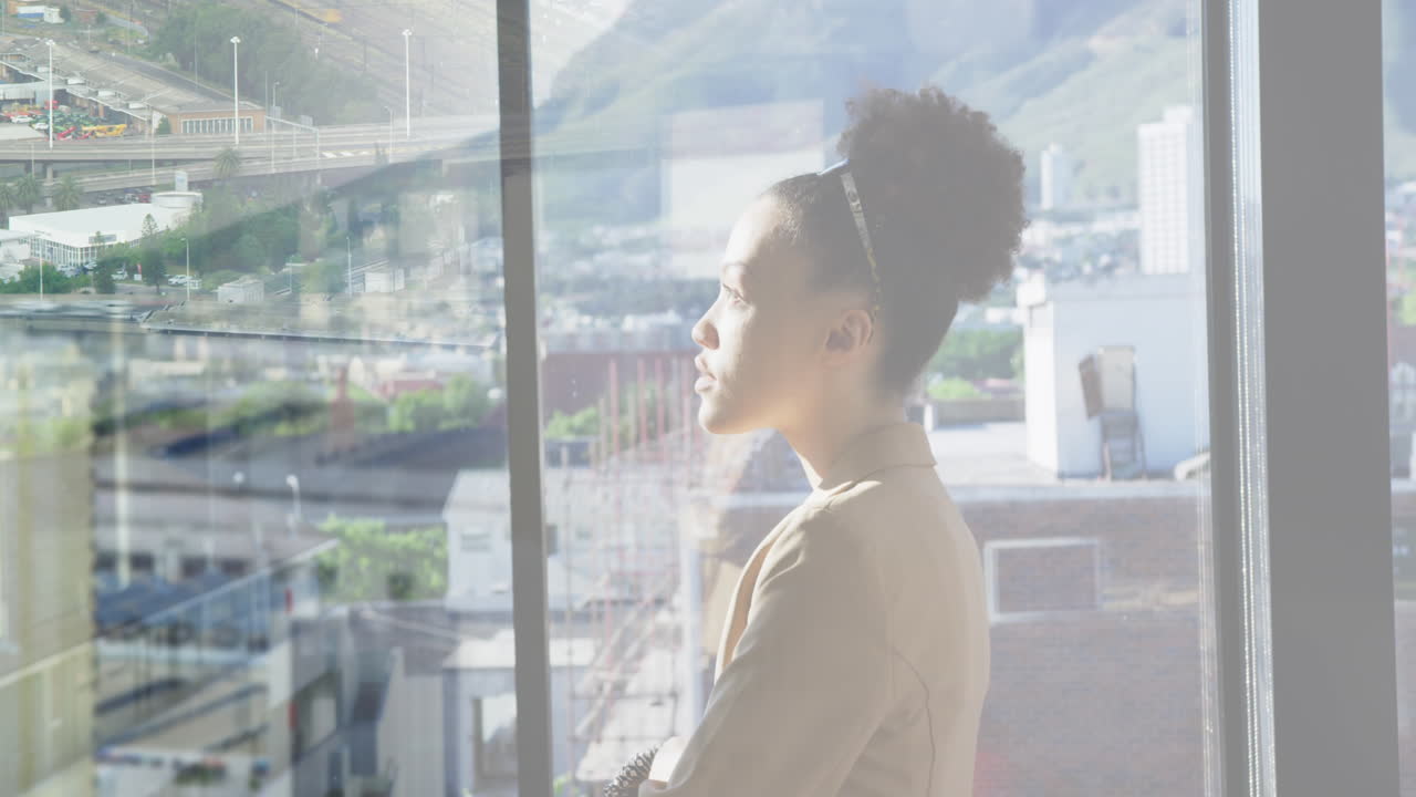 Animation of biracial businesswoman in office over people walking and cityscape