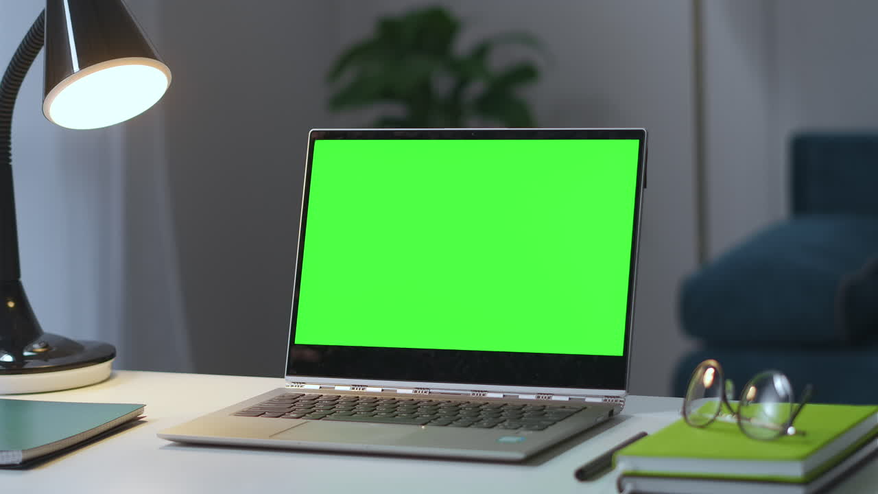 open notebook con schermata chiave chroma sul tavolo di lavoro in un salotto vuoto zooming shot che si avvicina al display verde utilizzando il portatile a casa