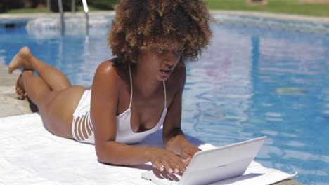 Charming-girl-using-laptop-in-pool