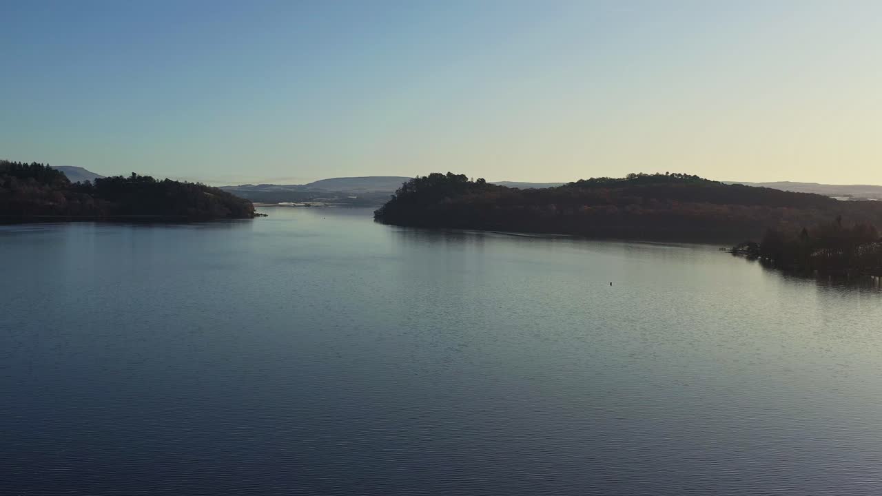 vistas aéreas al anochecer a través del lago de loch lomond y el parque nacional de los trossachs en escocia