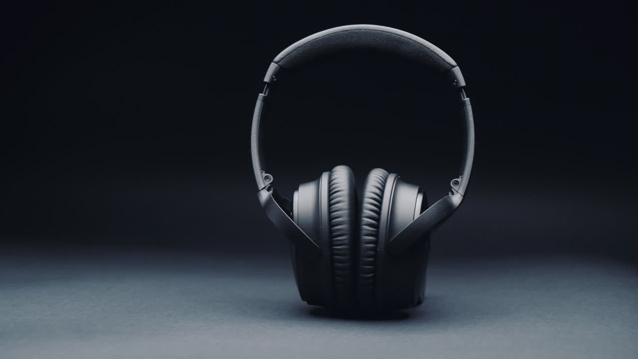 una foto de producto de auriculares negros sobre un fondo negro, de pie