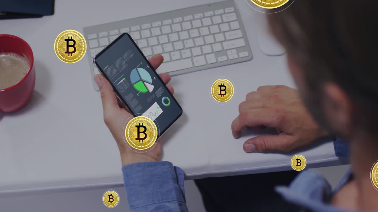 User holding smartphone displaying financial charts on desk, featuring keyboard and coffee mug
