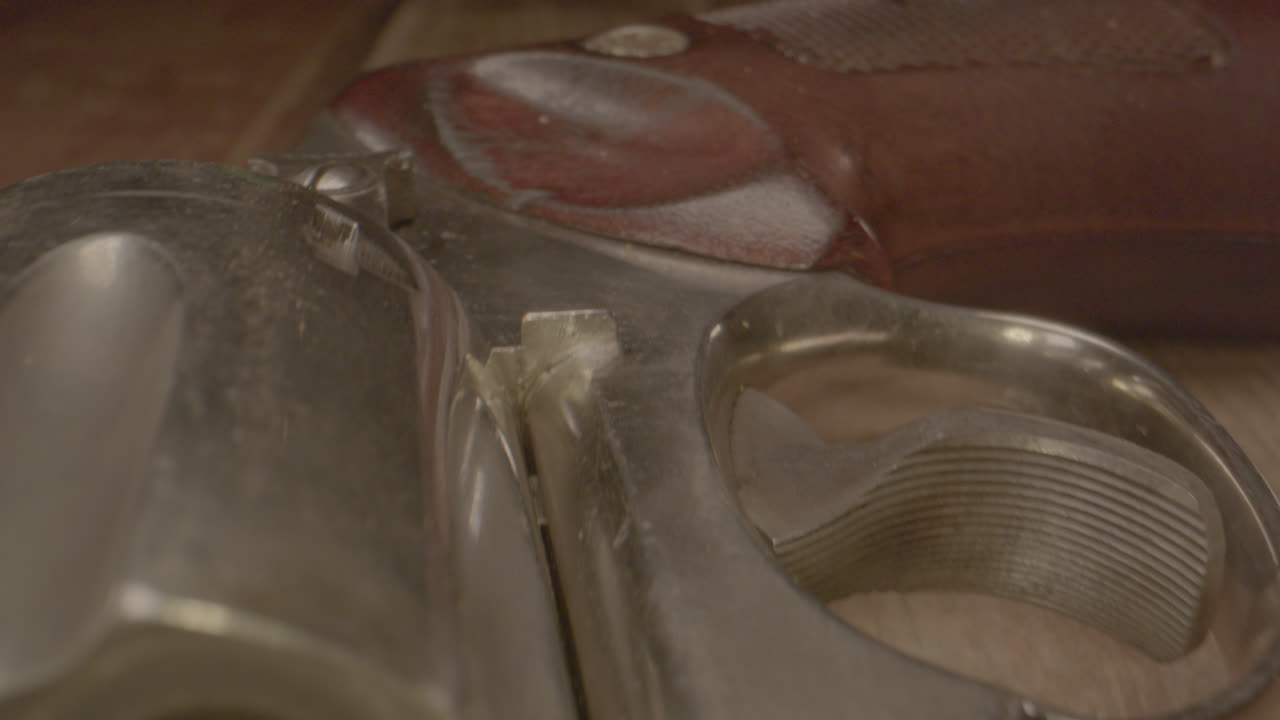 나무 테이블에 있는 오래된 서양식 리볼버의 매크로 돌리