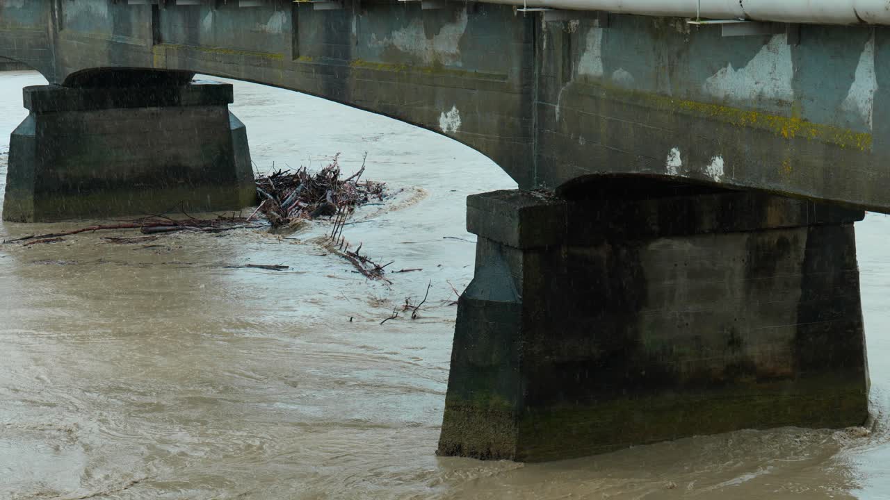 Intense footage capturing the impact of a cyclone as wood debris collects under a bridge, showcasing the raw force and aftermath of nature's fury