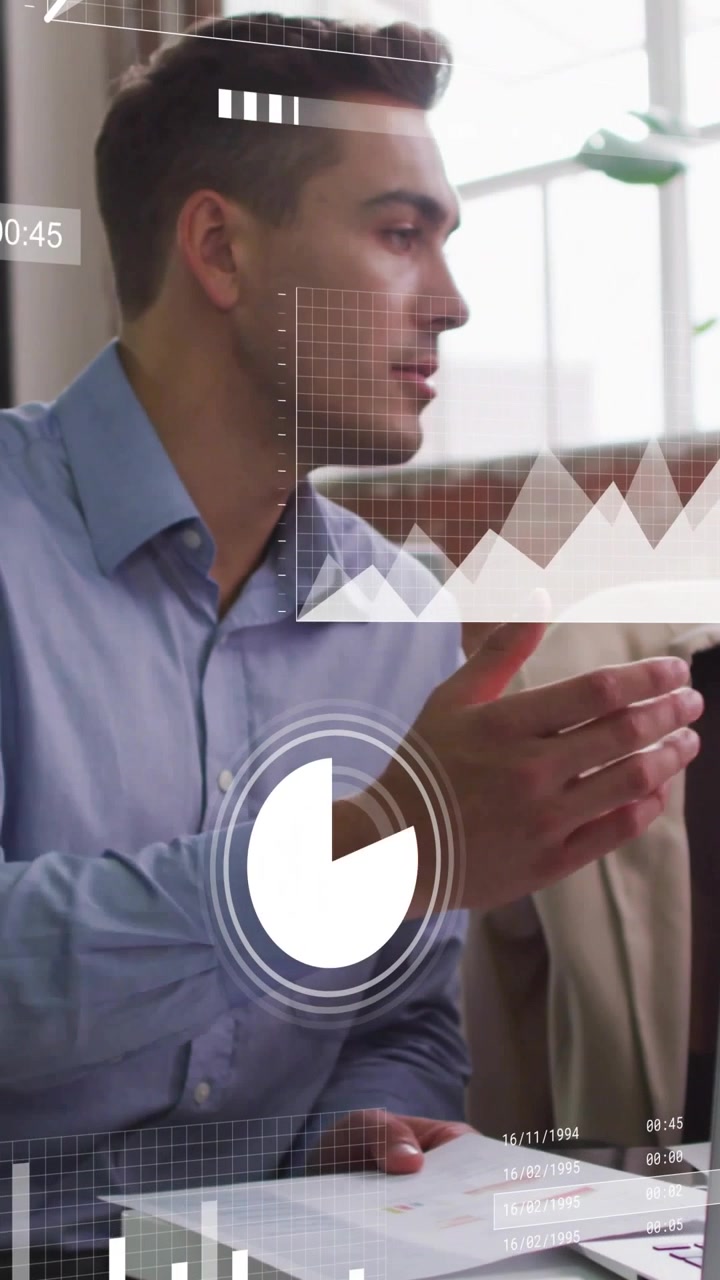 Man in blue shirt answering coworker data query, pointing at docs as animated charts overlaying