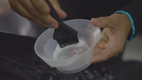 barber preparing hair mixture with brush