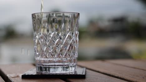 sequential filling of whiskey into a glass on a table