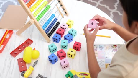 A child engages with colorful educational toys on a table, fostering creativity and learning in a bright, playful environment