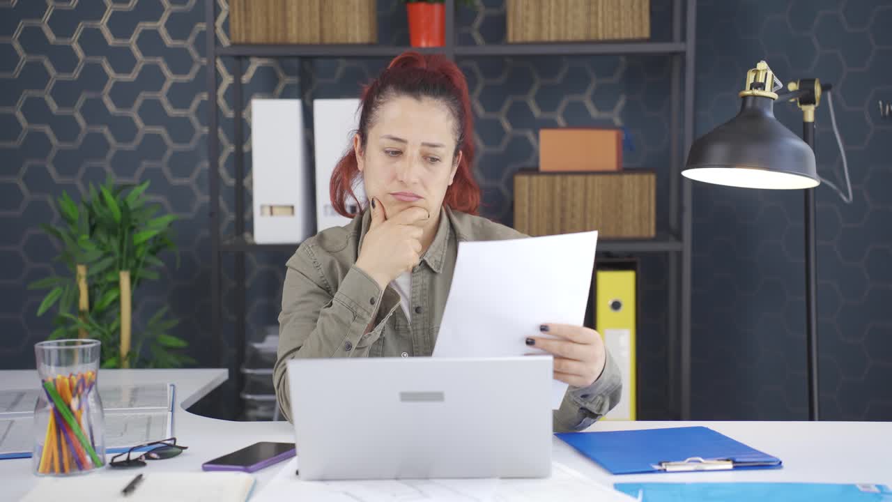 la mujer de negocios piensa mirando documentos.