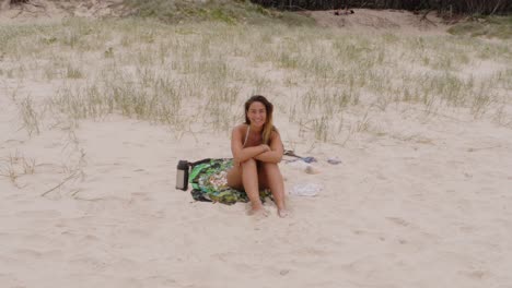 Pretty-Girl-Smiling-Seated-On-White-Sands-Of-Main-Beach,-Point-Lookout-In-North-Stradbroke-Island,-Queensland-Australia
