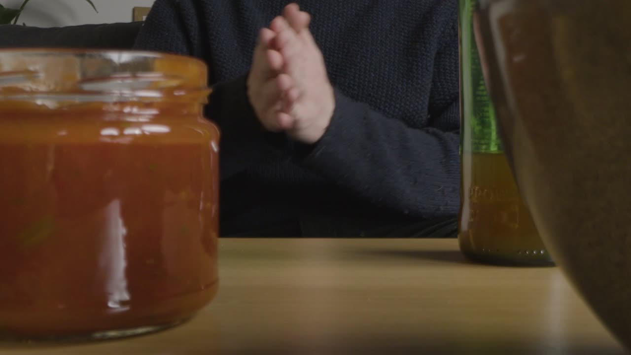 집에서 좌절한 사람이 tv에서 음료수 간식과 공 1로 미식축구 경기를 보고 있습니다.