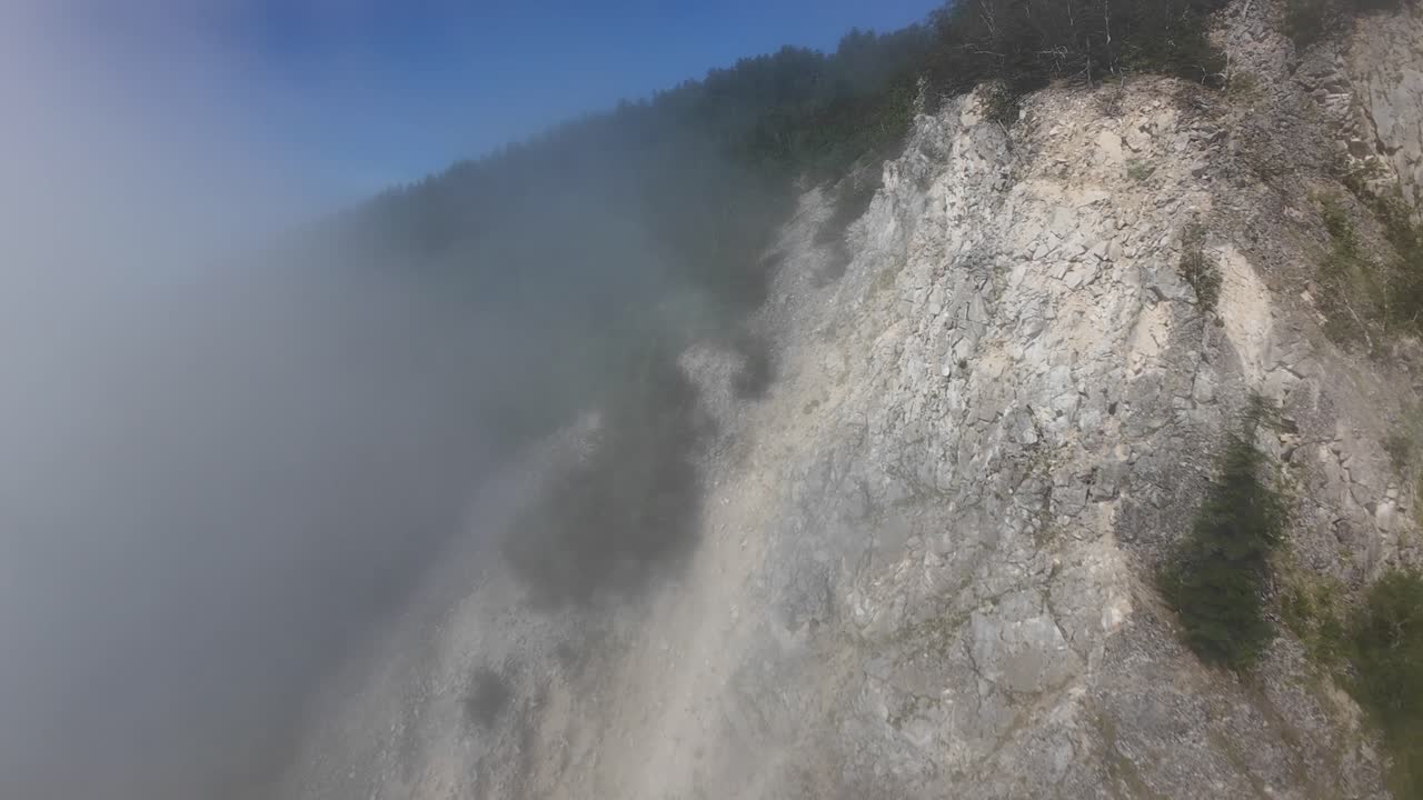 Experience breathtaking views of lush trees and swirling fog over mountains under a clear sky