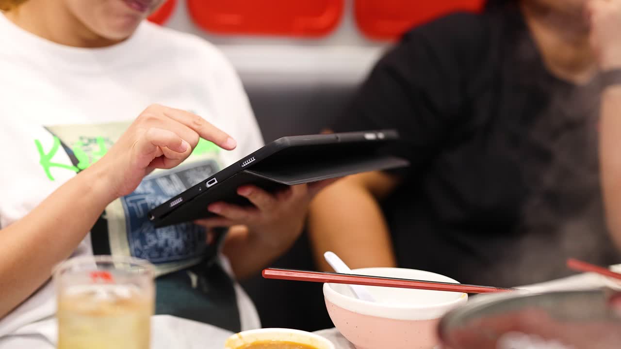 タブレットを使って料理を注文する人々