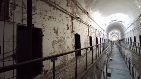 pan from left side of corridor to view down center of cellblock at eastern state penitentiary