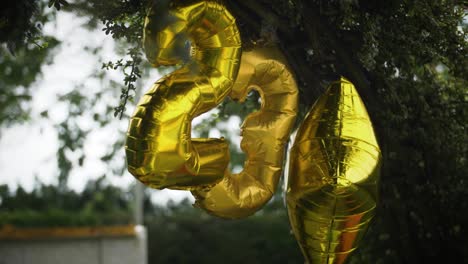 balão dourado de 23 anos pendurado em festa de verão no jardim