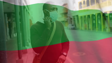 bandera búlgara ondeando contra un hombre que lleva una máscara facial