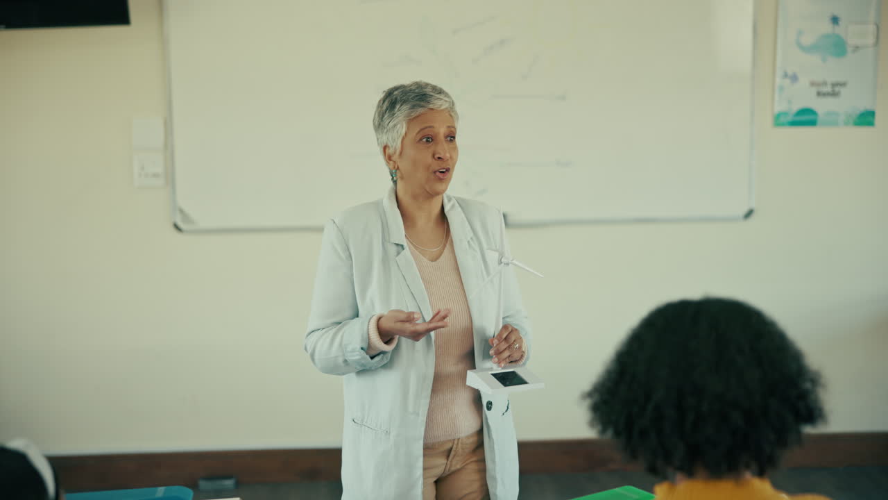 Teacher explaining wind turbine model in classroom