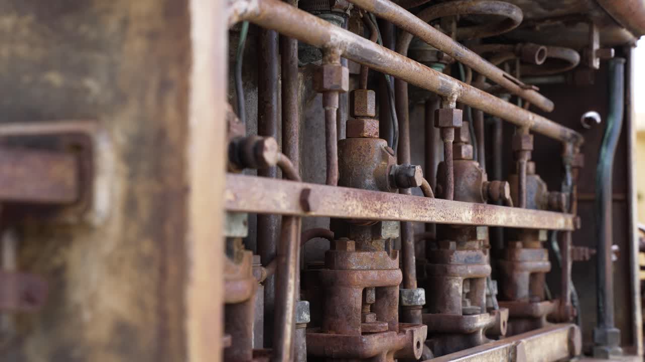 Detalje af gammel industrimotor, der viser rust og forfald, et glemt levn af teknologi