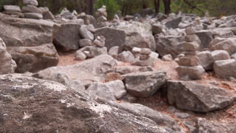 Tilting-up-shot-from-a-granite-rock-to-reveal-rows-of-cairns-all-grouped-together