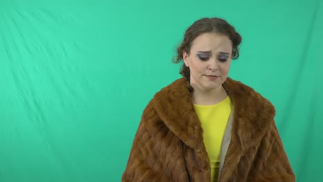 portrait of an anxious young lady with awkward face and actions standing against turquoise background - medium closeup shot