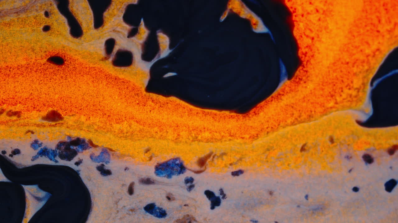 Colorful abstract ink patterns blending with black and orange streaks in liquid form