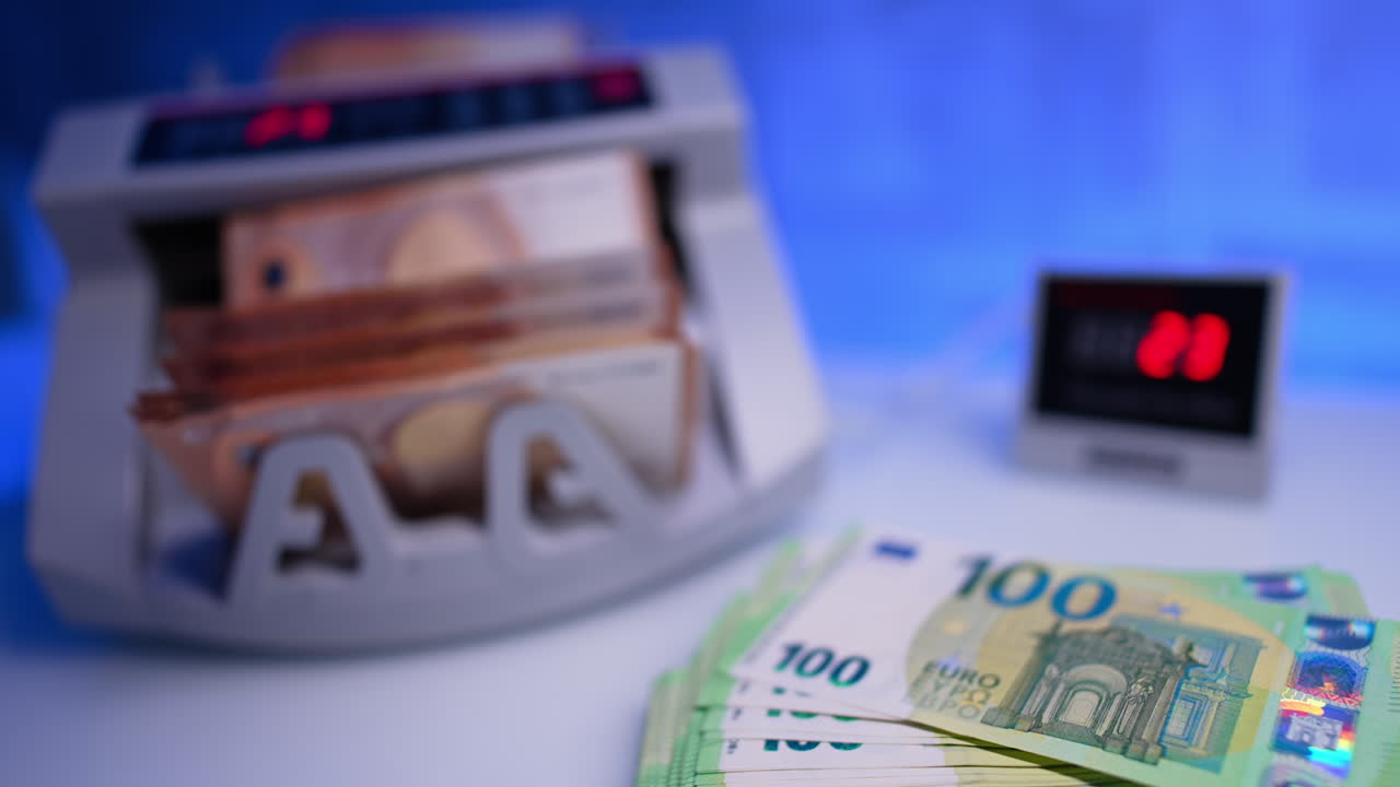 Money counted in bank equipment. Close up. Fifty euro stack in cash counting machine. Blurred backdrop.