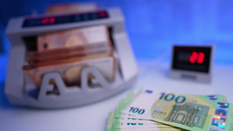 money counted in bank equipment. close up. fifty euro stack in cash counting machine. blurred backdrop.