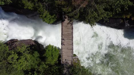 ascending aerial showing powerful river passing below small