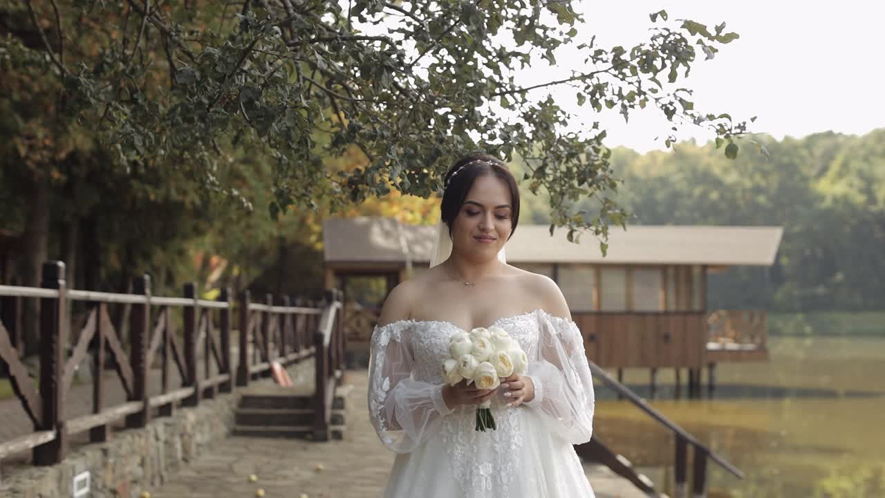 hermosa novia en vestido blanco sonriendo con un ramo
