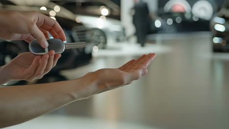 close-up of hands receiving car keys at a dealership