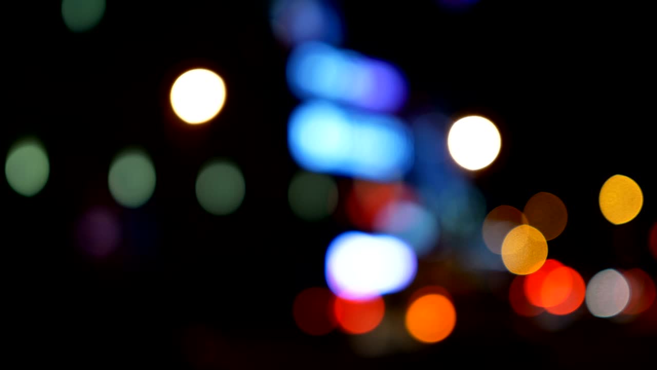 luces desenfocadas calle de los ángeles resumen. fondo borroso de la ciudad. círculos de bokeh en movimiento del tráfico nocturno.