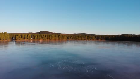 blauer himmel, der sich im eis des busjon-sees widerspiegelt, während sich die drohne schnell vorwärts bewegt