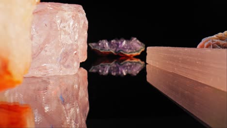 disparo de zoom entre cristales, minerales y piedras preciosas, reflejo debajo de ellos